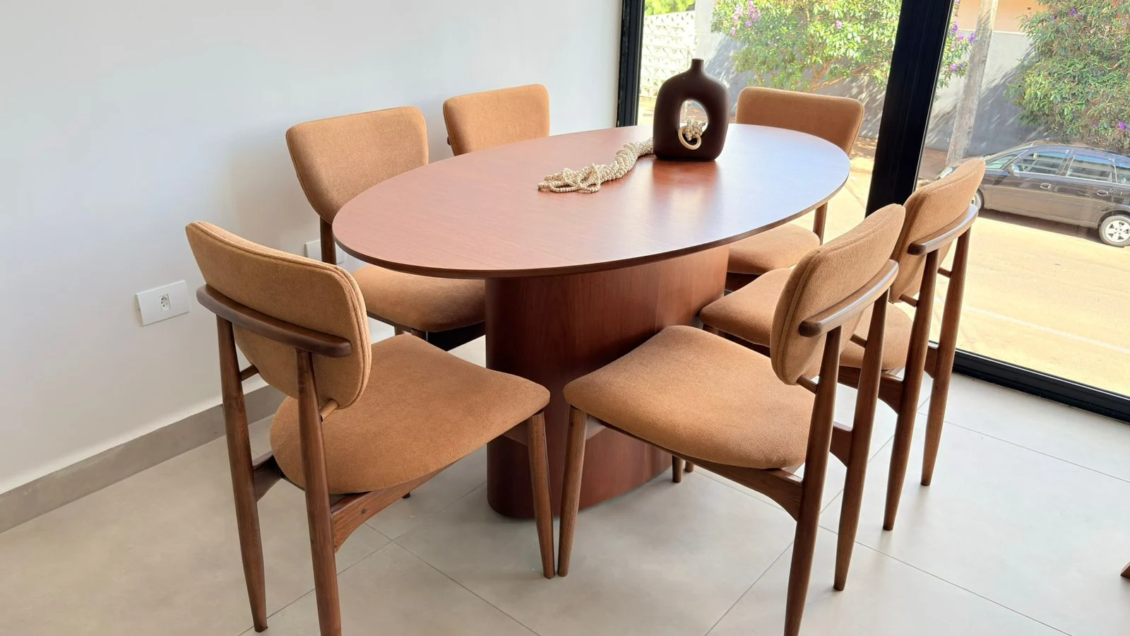 Sala de jantar com mesa oval e cadeiras terracota — Carolina Rocha Interiores